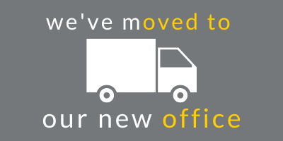 Dark grey background with a white graphic of a moving truck. Above the truck in white and yellow is written we've moved to and below the truck in white and yellow is written our new office.