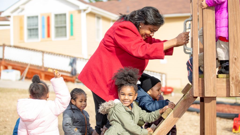 Juanisa Kimbrough on a playground with children from her daycare center.