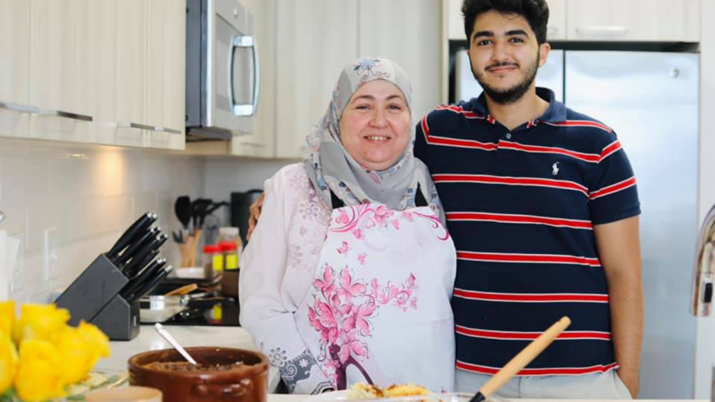 Sahar in her home kitchen standing next to her adult son.